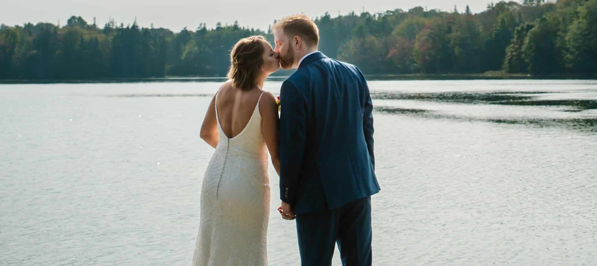 couple in wedding attire kissing overlooking body of water, Mill Pond