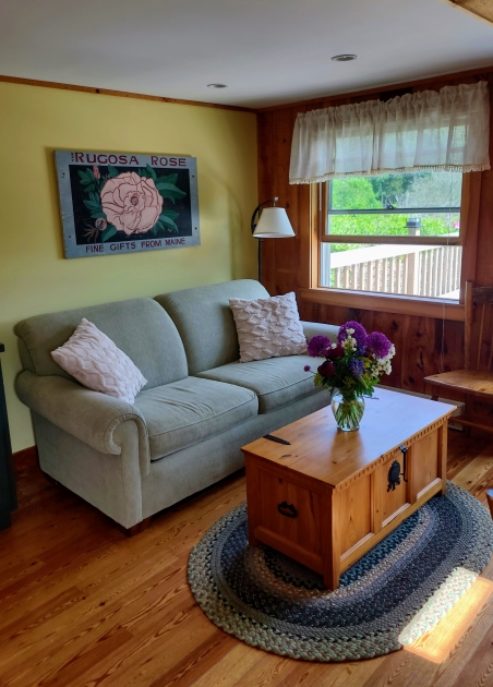 inside Rugosa Rose cottage featuring a couch and table with fresh flowers